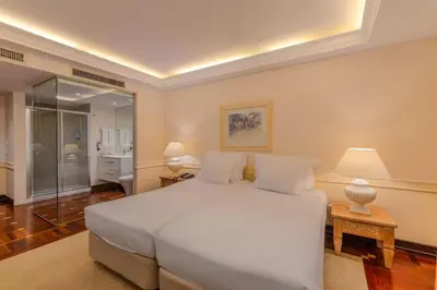 a bedroom with a large white bed with two lamps at Pestana Royal All Inclusive Ocean & Spa Resort in Funchal