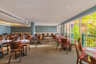 a dining room with tables and chairs and windows at Pestana Royal All Inclusive Ocean & Spa Resort in Funchal