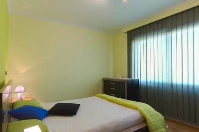 a small bedroom with a bed and a window at Casa do Serrado in Ponta do Sol