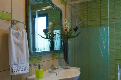 a bathroom with a sink with a vase with flowers in it at Casa do Serrado in Ponta do Sol