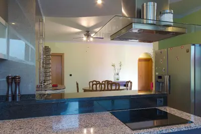 a kitchen with a table and chairs and a refrigerator at Casa do Serrado in Ponta do Sol