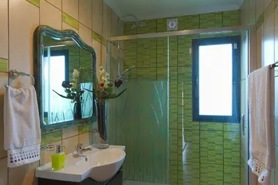 a bathroom with a sink and a shower with a mirror at Casa do Serrado in Ponta do Sol