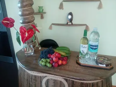 a table with a plate of fruit and a bottle of water at Casa do Serrado in Ponta do Sol