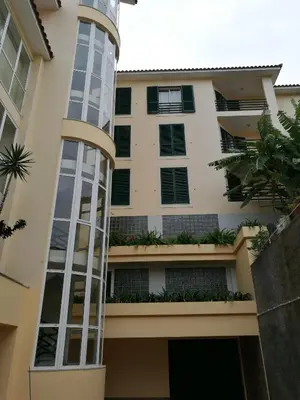 a building with a glass tower in front of it at Feel Funchal in Funchal