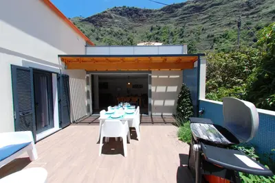 a patio with a table and chairs on a deck at Serenity in Jardim do Mar