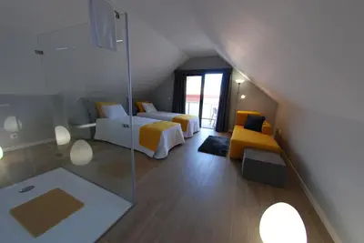 a attic room with two beds and a glass wall at Serenity in Jardim do Mar