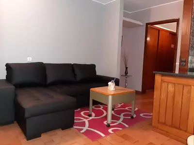 a living room with a black couch and a table at Apartamentos Matur in Machico