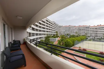 a balcony with chairs and a large building at Palace II in Funchal