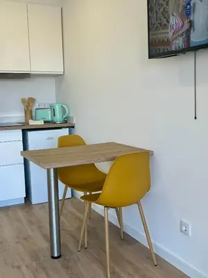 a wooden table and two yellow chairs in a kitchen at Feeling Like Home Machico in Machico