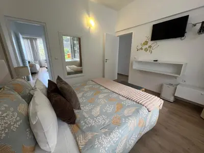 a bedroom with a couch and a tv on a wall at Feeling Like Home Machico in Machico