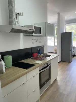 a white kitchen with a sink and a stove at Feeling Like Home Machico in Machico
