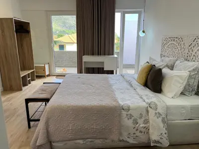 a bedroom with a large bed and a large window at Feeling Like Home Machico in Machico