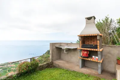 a bird house sitting on the side of a building at Casa da Tenda in Arco da Calheta
