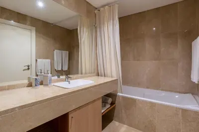 a bathroom with a sink and a bath tub and a tubermottermott at Virtudes Ocean view with pool by Holiday Rental Madeira in Funchal