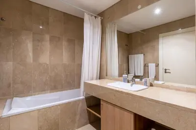 a bathroom with a tub and a sink and a bath tubermottermott at Virtudes Ocean view with pool by Holiday Rental Madeira in Funchal