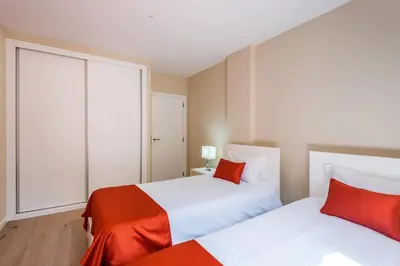 a bedroom with two beds with red pillows at Funchal SilverWood Apartment - by LovelyStay in Funchal