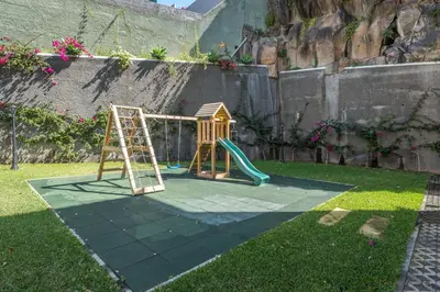 a playground with a slide and a ladder in a yard at Funchal SilverWood Apartment - by LovelyStay in Funchal