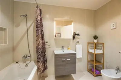 a bathroom with a tub and a sink and a shower at Funchal SilverWood Apartment - by LovelyStay in Funchal