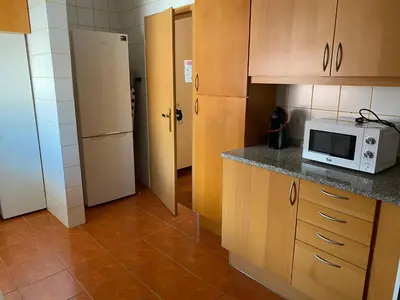 a kitchen with a microwave on a counter and a refrigerator at FLH Garajau Balcony with Pool in Caniço