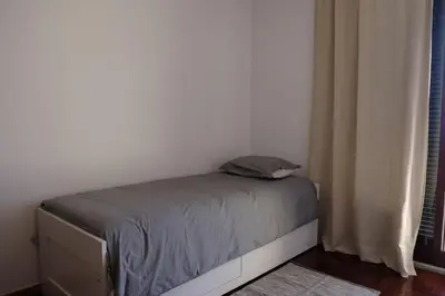 a bed with a pillow on it in a bedroom at FLH Garajau Balcony with Pool in Caniço