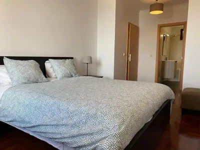 a bedroom with a large bed with two pillows at FLH Garajau Balcony with Pool in Caniço