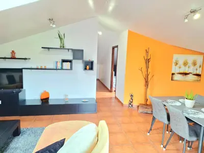 a living room with a table and a tv at Discovery Apartment in Santana