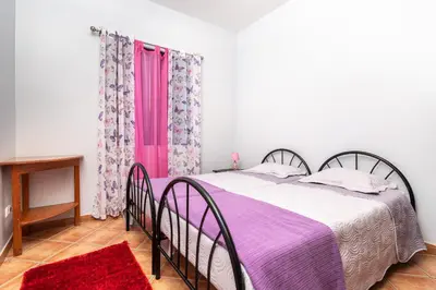 a bedroom with a bed and a pink window at Casa das Camélias in Arco da Calheta
