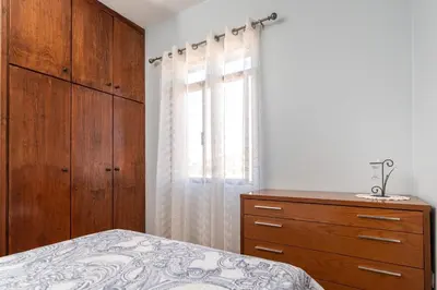 a bedroom with a bed and a dresser and a window at Casa das Camélias in Arco da Calheta