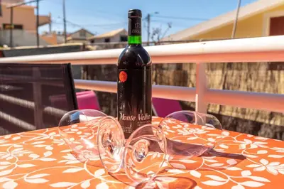 a bottle of wine sitting on a table with glasses at Casa das Camélias in Arco da Calheta
