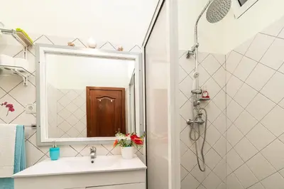a bathroom with a sink and a shower with a mirror at Casa das Camélias in Arco da Calheta