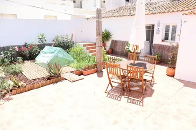 a patio with a table and chairs and plants at Salema Beach Private Villa in Salema