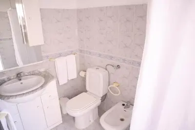 a bathroom with a white toilet and a sink at Salema Beach Private Villa in Salema