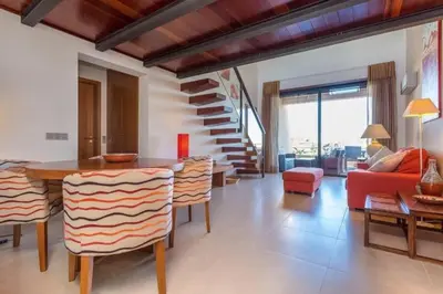 a living room with a red couch and a table and chairs at Mar da Luz in Luz