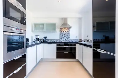 a kitchen with white cabinets and a stove top oven at Mar da Luz in Luz