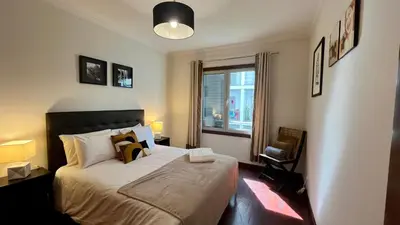 a bedroom with a large bed and a window at Madeira Emotions Apartments in Funchal