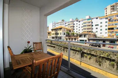 a balcony with a table and a view of a city at Madeira Emotions Apartments in Funchal