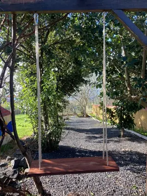 a wooden swing in the middle of a garden at Casa da Rocha in Calheta