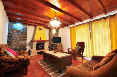 a living room with a couch and a fireplace at Casa da Rocha in Calheta