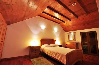 a bedroom with a bed and a wooden ceiling at Casa da Rocha in Calheta