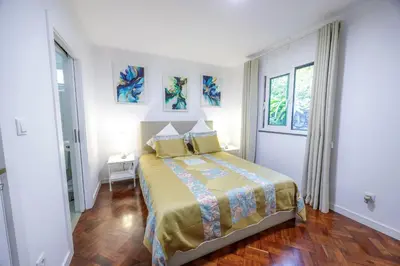 a bedroom with a bed and two windows at Casa Maravilha in Caniço