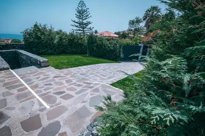 a garden with a stone walkway in a yard at Casa Maravilha in Caniço