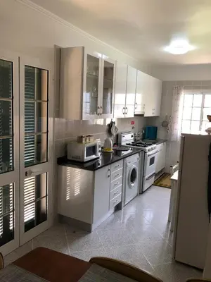 a kitchen with white cabinets and a stove top oven at Apartment with beautiful ocean and city view in Funchal