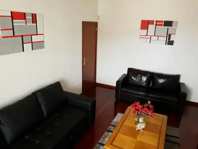 a living room with a couch and a table with flowers at Apartment with beautiful ocean and city view in Funchal