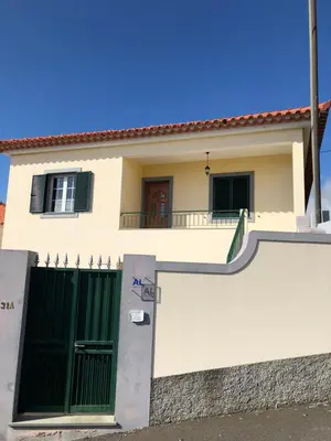 a white house with a gate and a fence at Apartment with beautiful ocean and city view in Funchal