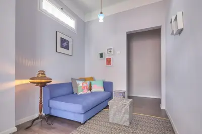 a living room with a blue couch and a door at Endemic - Concept Apartment in Funchal
