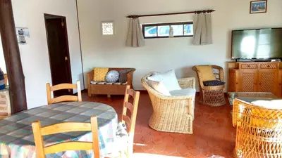 a living room with chairs and a table and a television at Quinta Falzina in Luz