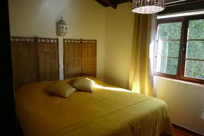 a bedroom with a bed with yellow sheets and a window at Quinta Falzina in Luz