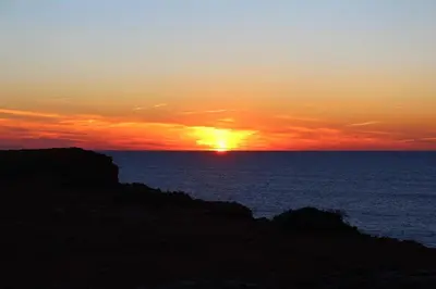 a sunset over the ocean with the sun setting at Sagres Sunny Room with private bathroom 300m from the beach in Sagres