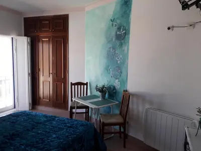 a bedroom with a bed and a table with chairs at Sagres Sunny Room with private bathroom 300m from the beach in Sagres