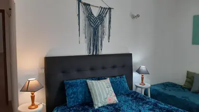 a bedroom with a bed with blue sheets and two lamps at Sagres Sunny Room with private bathroom 300m from the beach in Sagres